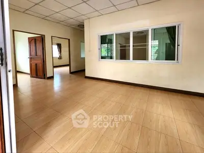 Spacious living room with wooden flooring and large window, perfect for natural light.