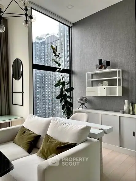 Modern living room with high ceilings and large windows offering city views.