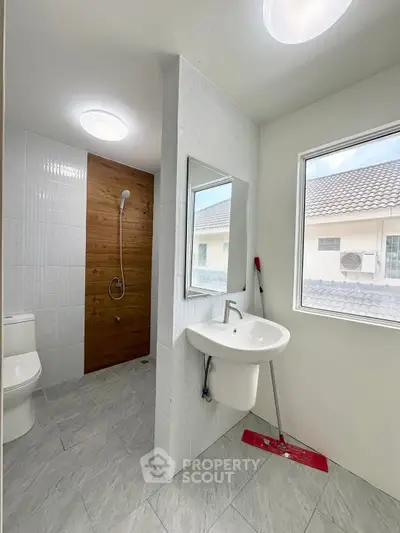 Modern bathroom with sleek fixtures and large window offering natural light.