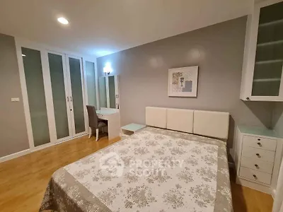 Spacious bedroom with elegant decor and ample storage in modern apartment.