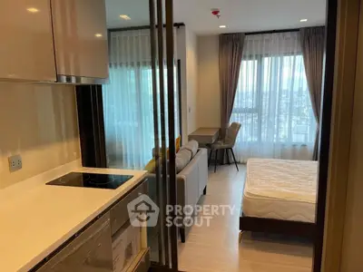 Modern studio apartment with open layout, featuring a cozy living area and sleek kitchen design.