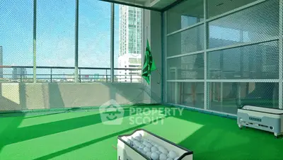 Modern indoor golf practice area with green turf and city view, perfect for sports enthusiasts.