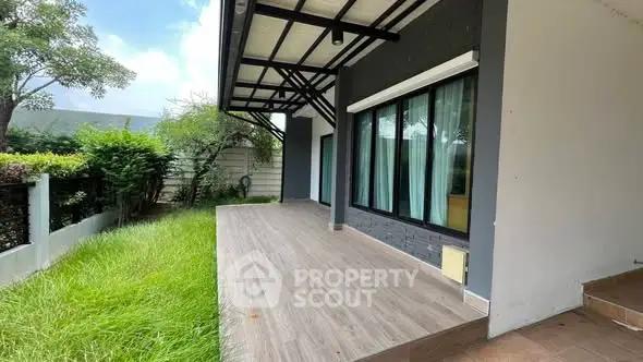 Modern patio with wooden flooring and lush green garden view