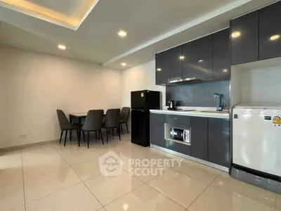 Modern kitchen with sleek cabinetry and dining area in open layout apartment
