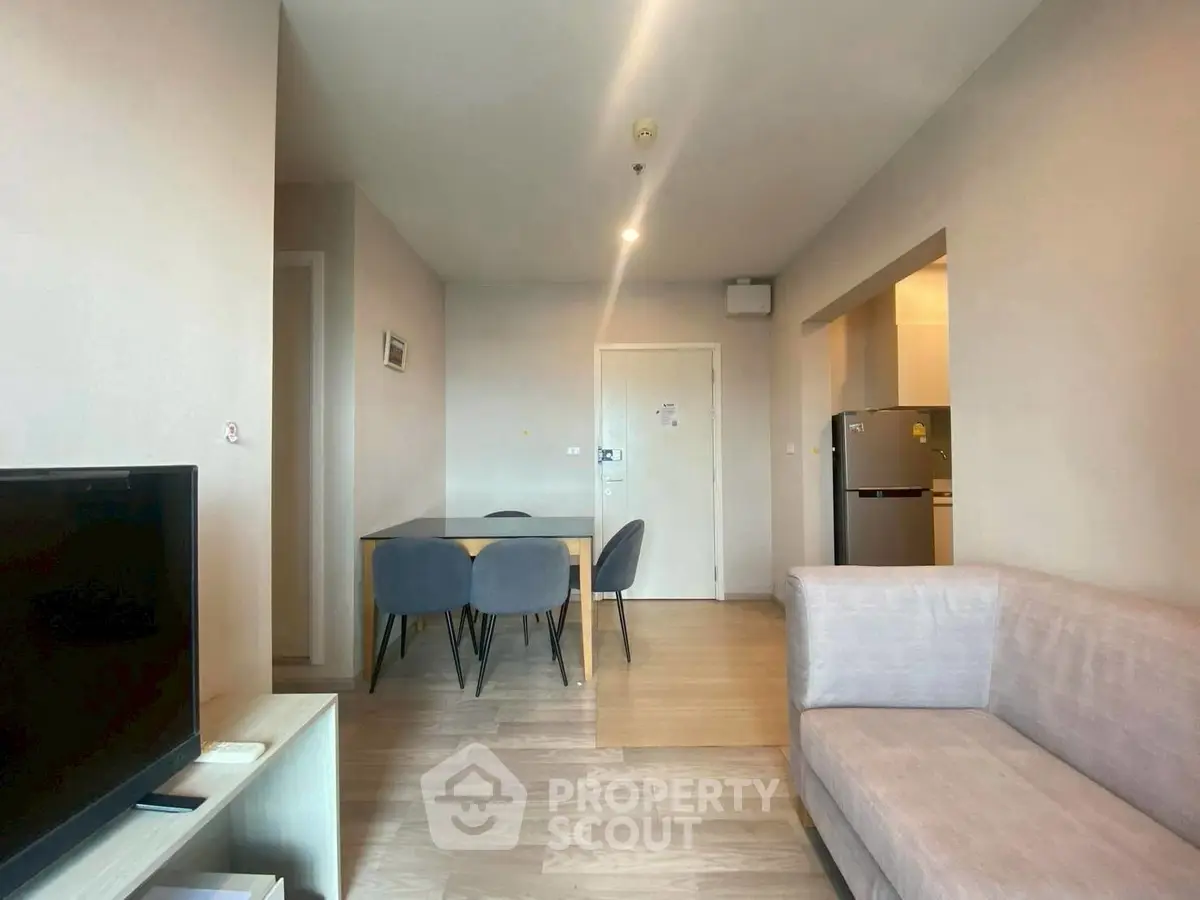 Modern living room with dining area and kitchen in open layout apartment.