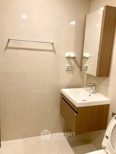 Modern bathroom with sleek vanity and neutral tiles, perfect for a contemporary home.