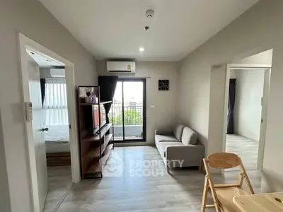 Modern living room with balcony access and stylish furniture in a cozy apartment.