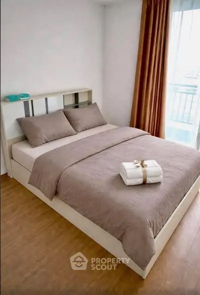 Cozy bedroom with modern decor and natural light, featuring a comfortable bed and elegant curtains.