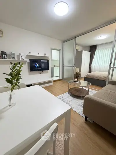 Modern open-plan living room with stylish decor and cozy bedroom view
