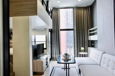 Modern living room with high ceilings and large windows in a stylish apartment.