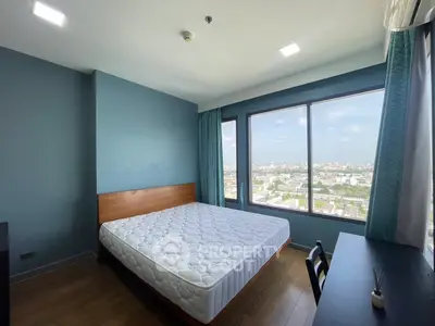 Spacious bedroom with large window offering stunning city view