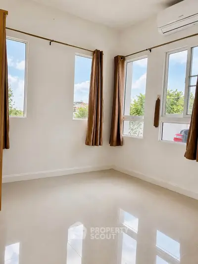 Bright empty room with large windows and air conditioning, perfect for customization.