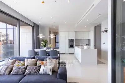 Luxurious open-plan living room and kitchen with modern decor and large windows.