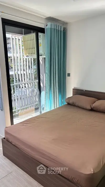 Modern bedroom with balcony access and stylish decor in a contemporary apartment.