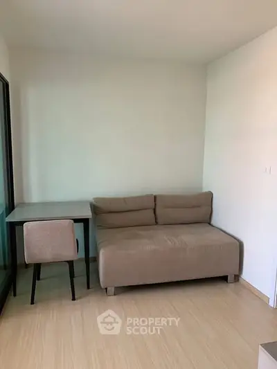 Cozy small living room with a sofa and desk, perfect for compact spaces.