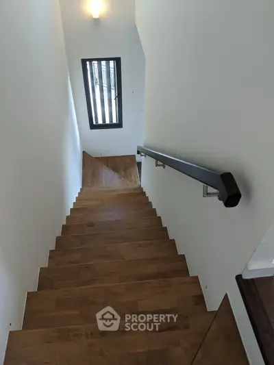 Elegant wooden staircase with modern railing in a stylish home interior