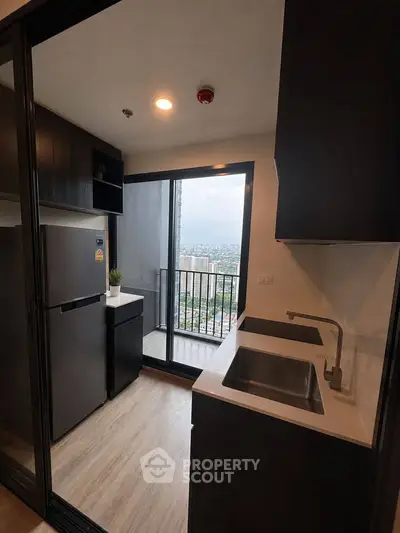 Modern kitchen with balcony view in high-rise apartment