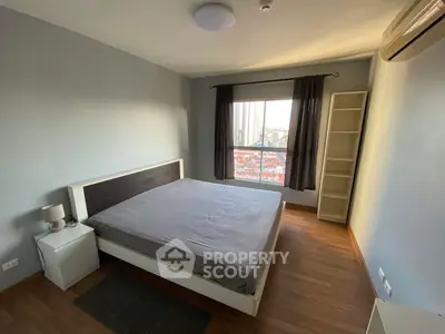 Spacious bedroom with modern decor and city view window