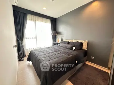 Modern bedroom with sleek black decor and large window for natural light