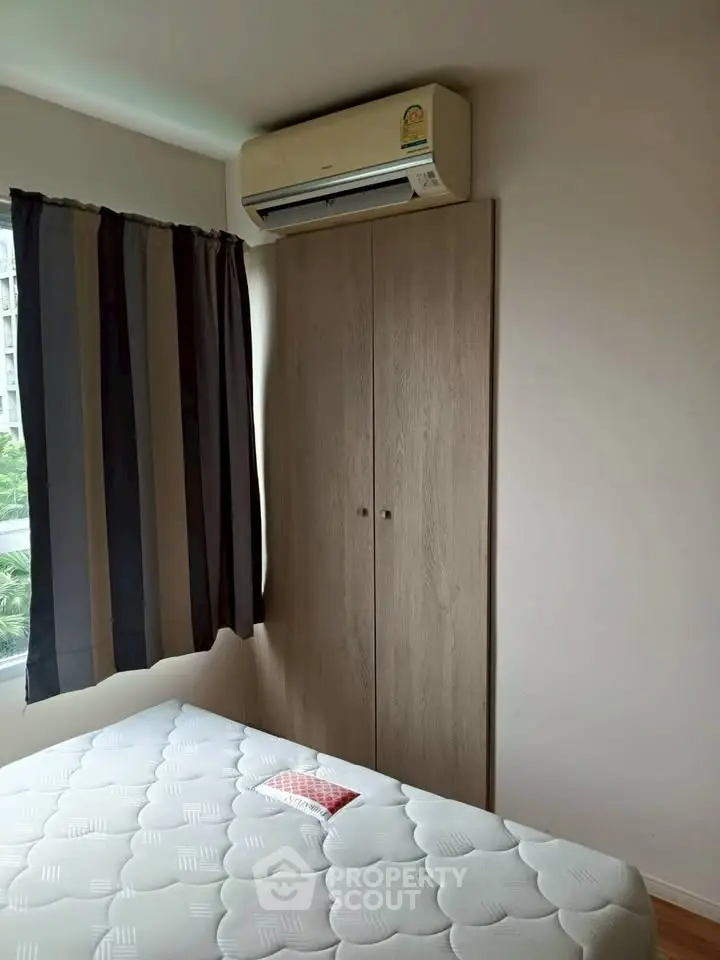 Cozy bedroom with air conditioning and wardrobe, perfect for comfortable living.