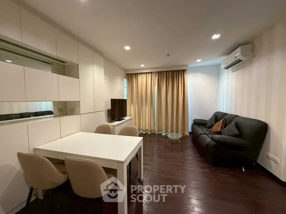 Modern living room with sleek furniture and elegant decor, featuring a cozy sofa and dining area.
