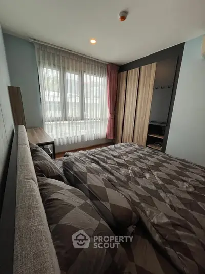 Cozy bedroom with modern decor and large window for natural light