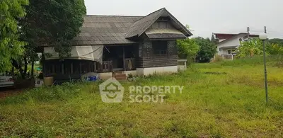 Charming rustic wooden house with spacious green yard in serene neighborhood.