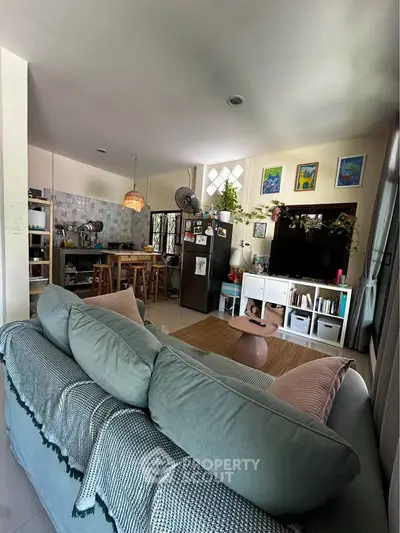 Charming open-layout living room with cozy sofa, modern kitchen, and stylish decor in a bright, inviting space.