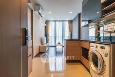 Modern open-plan living room and kitchen with washing machine and stylish decor.