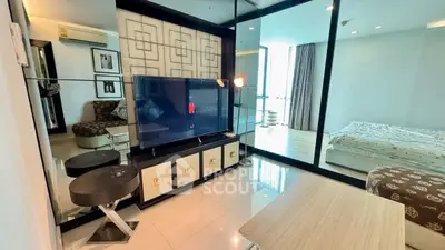 Modern living room with TV and glass partition leading to bedroom