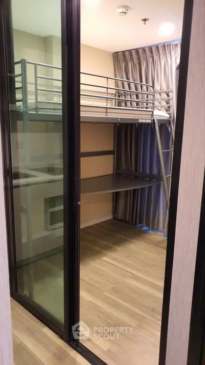 Modern bedroom with loft bed and wooden flooring in a stylish apartment.