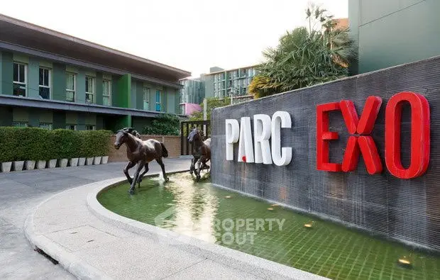 Modern building entrance with water feature and horse sculptures at Parc Exo.