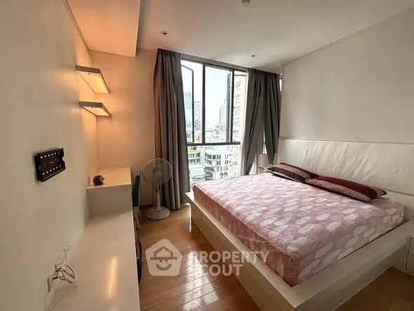 Modern bedroom with city view, featuring stylish decor and ample natural light.