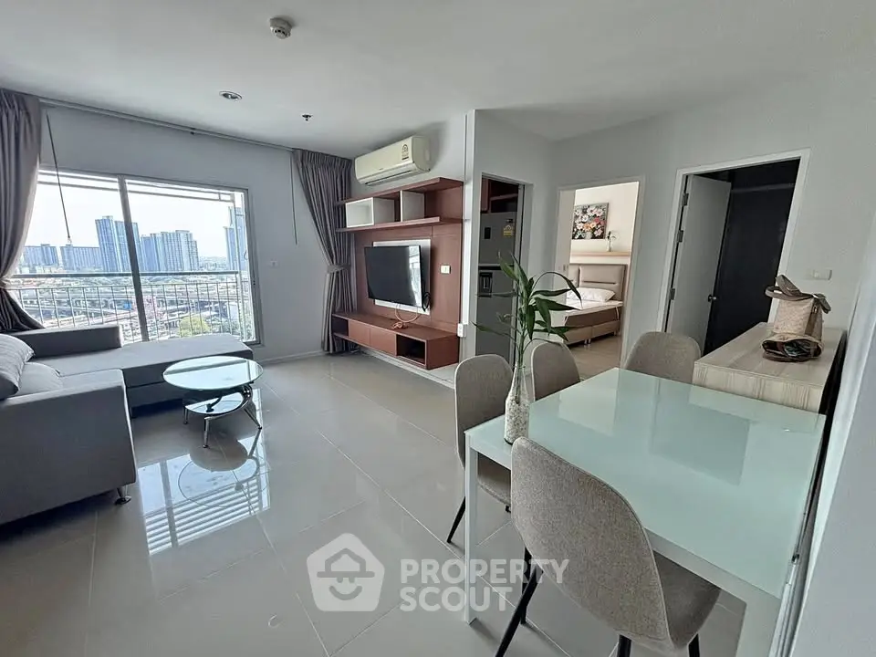 Modern open-plan living room with city view, stylish furniture, and natural light.