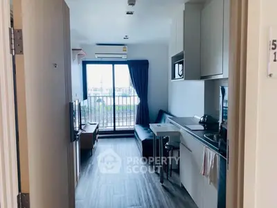 Modern apartment with open kitchen and balcony view, featuring sleek design and natural light.