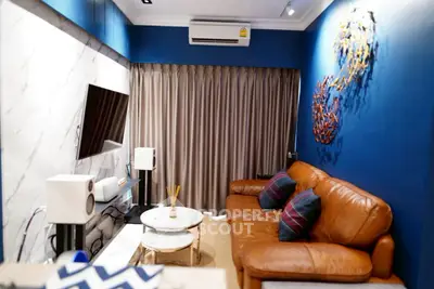 Stylish living room with leather sofa, modern decor, and wall-mounted TV in a cozy apartment.