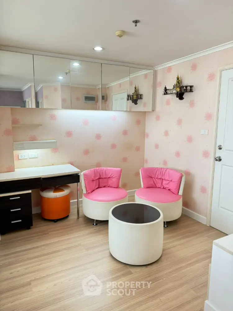 Charming study room with pink chairs and floral wallpaper, perfect for a cozy workspace.