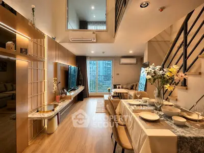Luxurious modern living room with open layout and elegant dining area, featuring large windows and stylish decor.
