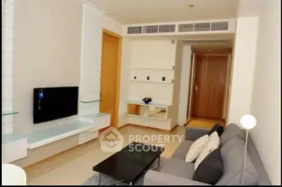 Modern living room with sleek furniture and wall-mounted TV in a stylish apartment.
