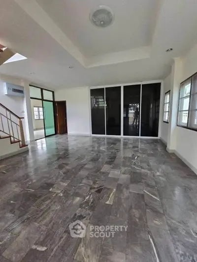 Spacious living room with modern flooring and large windows for natural light.