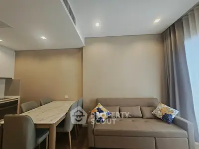 Modern living room with stylish sofa and dining area in open layout apartment.