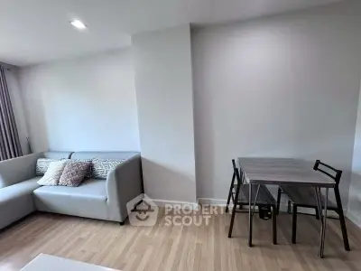 Modern living room with sleek sofa and dining table, featuring minimalist design and cozy ambiance.