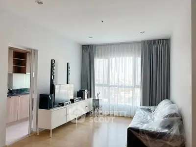 Spacious living room with modern decor and large window offering natural light.