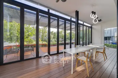 Modern dining area with floor-to-ceiling windows and outdoor view, featuring sleek furniture and contemporary lighting.