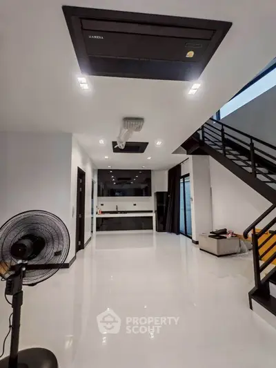 Modern open-concept living space with sleek staircase and minimalist design