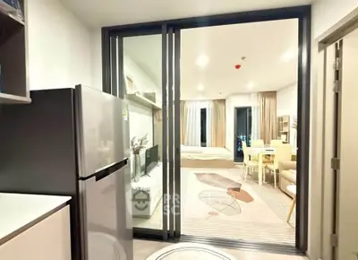 Modern open-layout apartment with sleek kitchen and cozy living area, featuring stylish decor and ample natural light.