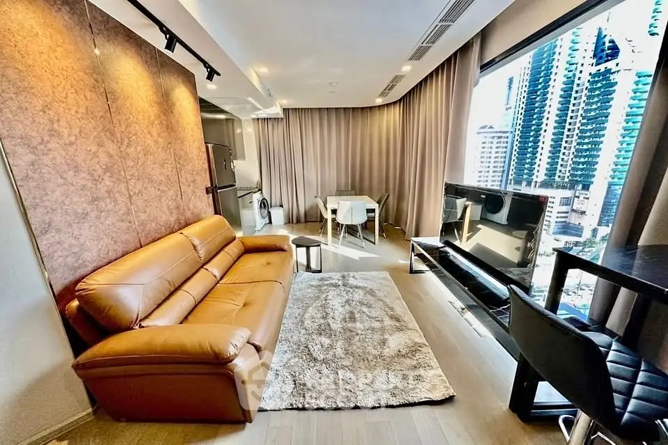 Modern living room with city view, leather sofa, and sleek decor in a high-rise apartment.