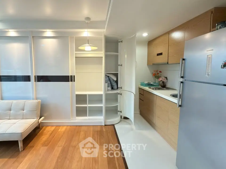 Modern studio apartment with sleek kitchen and ample storage space