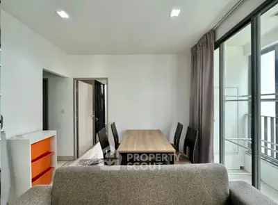 Modern living room with dining area and large windows in a stylish apartment.