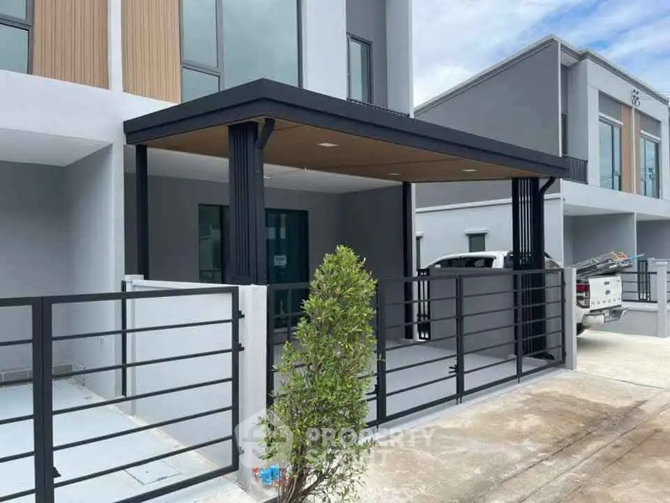 Modern townhouse exterior with sleek design and carport